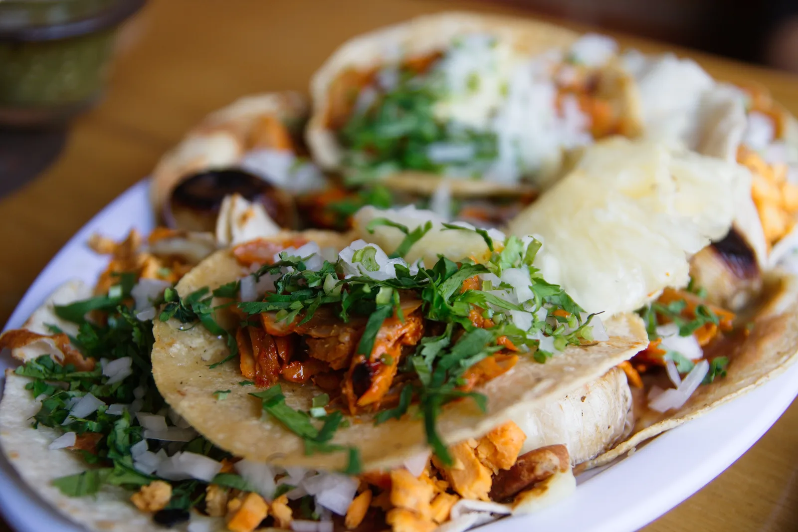 A plate of tacos al pastor topped with onion and cilantro. The photo was not taken at a Sandy Springs restaurant.