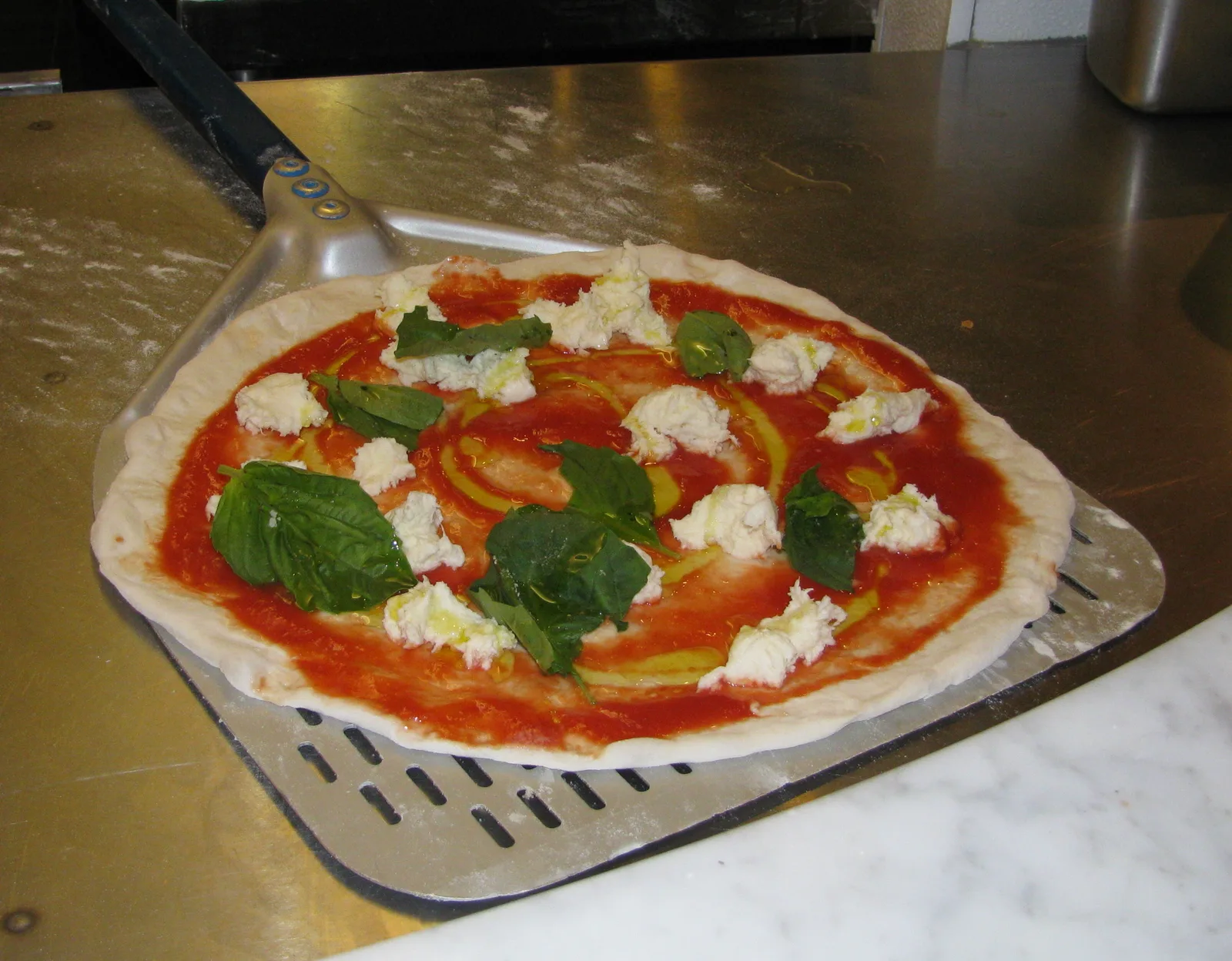 A Margherita-style pizza on a peel, ready for the oven. The photo was not taken at a Sandy Springs restaurant.